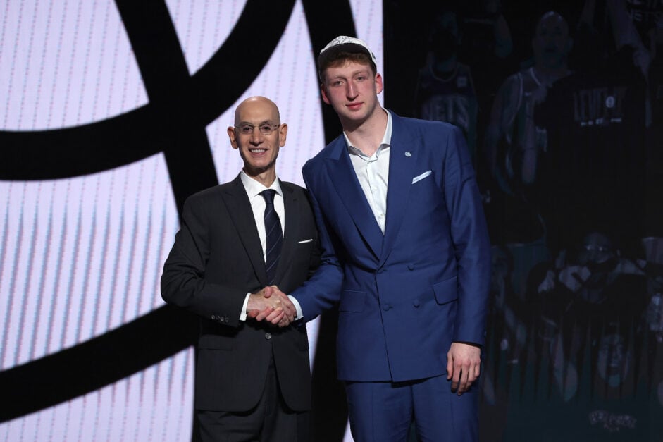 Danny Wolf (R) shakes hands with NBA commissioner Adam Silver (L) after being drafted twenty-seventh overall by the Brooklyn Nets during the first round of the 2025 NBA Draft.