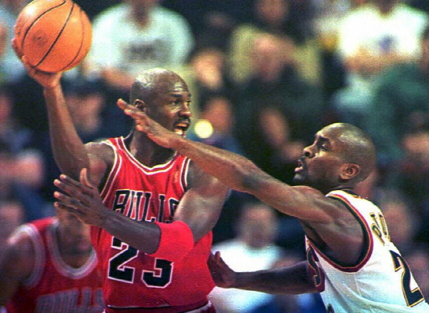 Michael Jordan of the Chicago Bulls tries to pass the ball as Seattle Supersonics' Gary Payton plays suffocating defense.