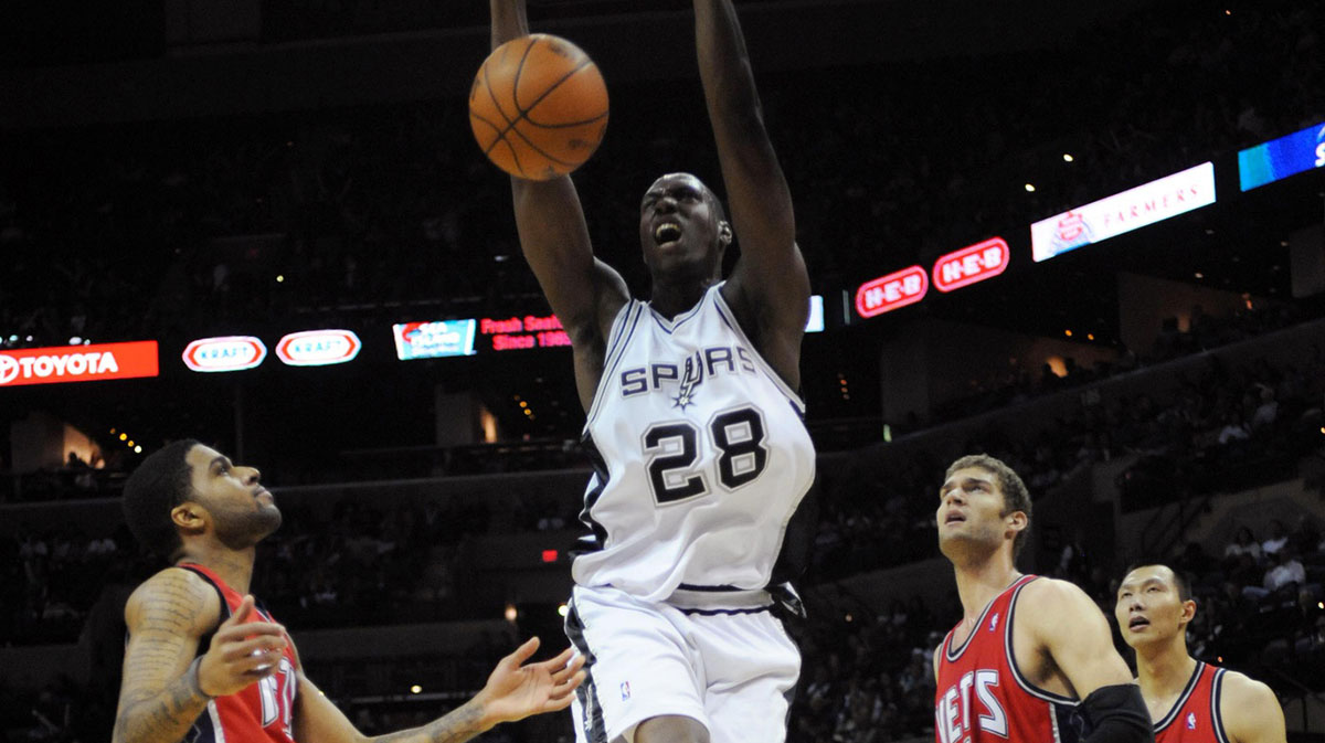 San Antonio Spurs center Ian Mahinmi (28) dunks over New Jersey Nets guard Chris Douglas-Roberts (17), center Brook Lopez (11) and forward Yi Jianlian (left) during the fourth quarter at the AT&T Center. San Antonio beat New Jersey 97-85.