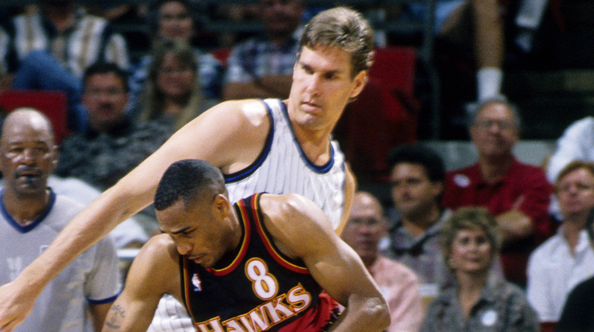 Atlanta Hawks guard Steve Smith (8) drives to the basket defended by Orlando Magic forward Jon Koncak (45) in the 1995-96 NBA Playoffs at the Orlando Arena. 