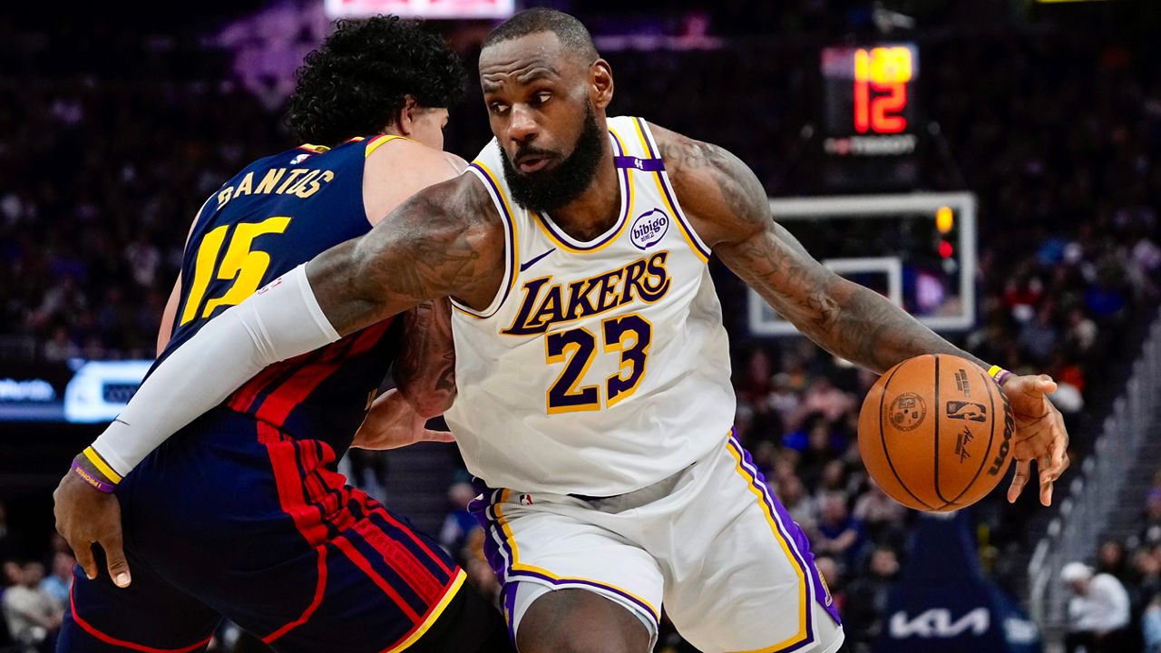 Los Angeles Lakers forward LeBron James, right, moves the ball while defended by Golden State Warriors forward Gui Santos during the first half of an NBA basketball game Saturday, Jan. 25, 2025, in San Francisco.