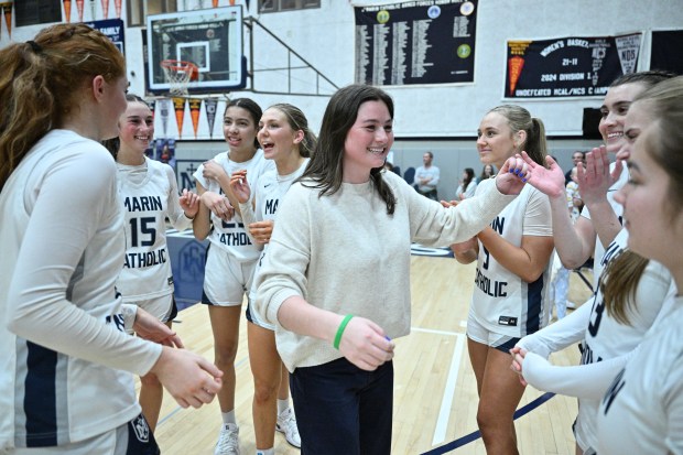 Marin Catholic girls basketball head coach Kayden Korst congratulates each...