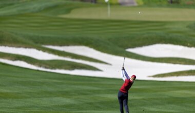 Ball flys as golfer follows through.