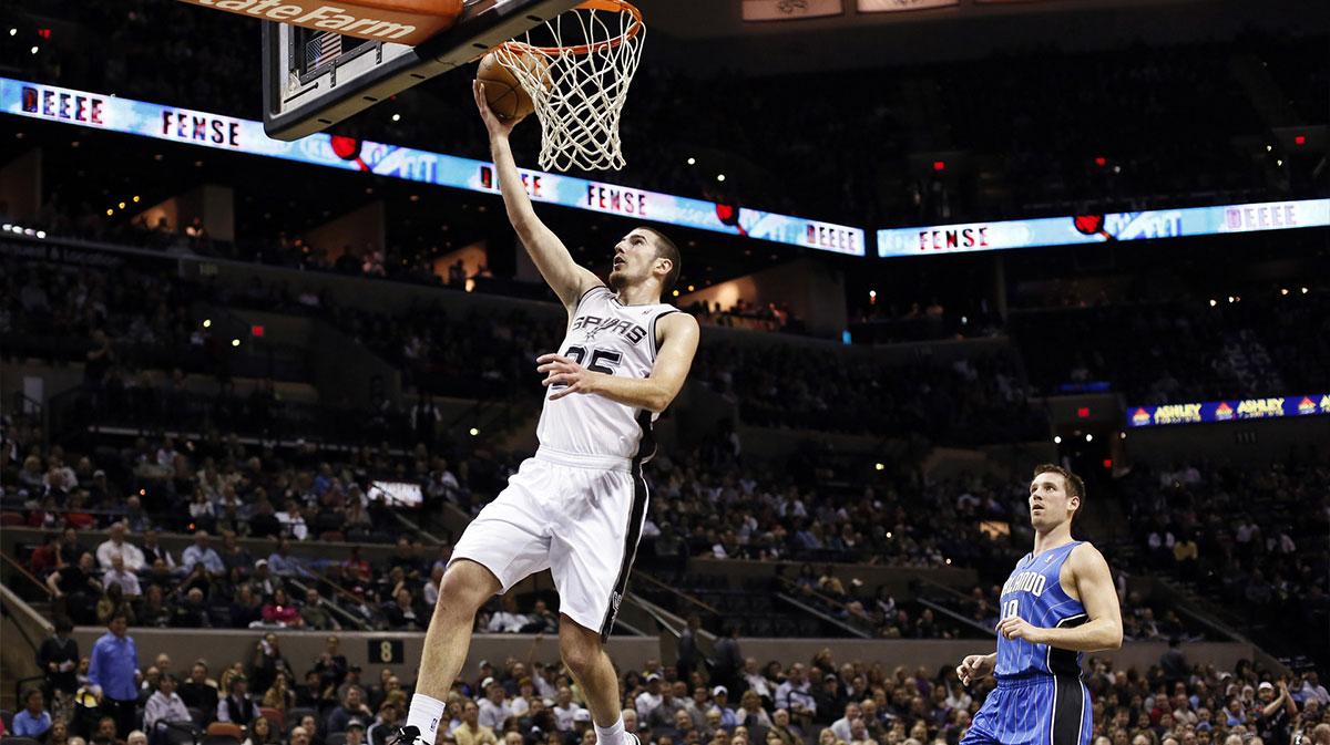 San Antonio Spurs guard Nando De Colo (25) drives to the basket as Orlando Magic guard Beno Udrih (19) looks on during the first half at the AT&T Center.