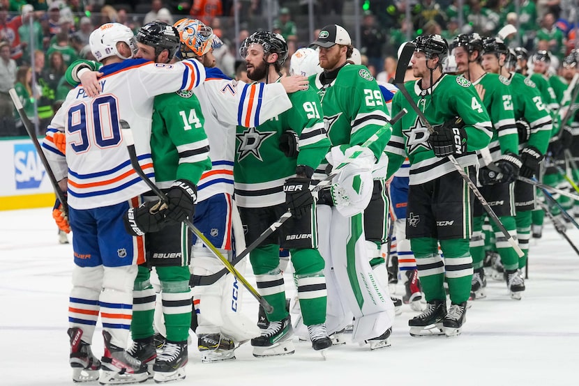 Dallas Stars left wing Jamie Benn (14) hugs Edmonton Oilers right wing Corey Perry (90)...