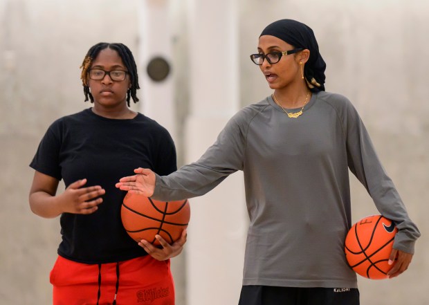Jamad Fiin gives dribbling instructions to Reniyah Boston, 14, at...