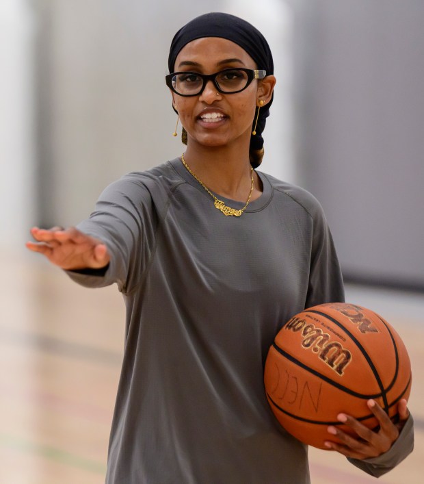 Jamad Fiin gives instruction to a group of young basketball...