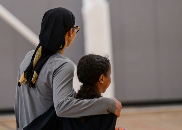 Jamad Fiin, left, welcomes a young basketball player at the...