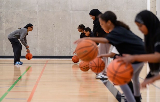 Jamad Fiin works with a group of young basketball players...