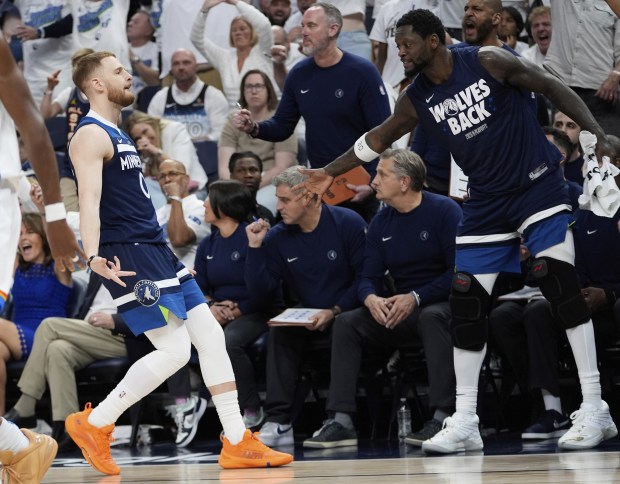 Minnesota Timberwolves guard Donte DiVincenzo, left, is congratulated by forward Julius Randle, right, after making a 3-point basket during the second half of Game 4 of the Western Conference finals of the NBA basketball playoffs against the Oklahoma City Thunder Monday, May 26, 2025, in Minneapolis. (AP Photo/Abbie Parr)