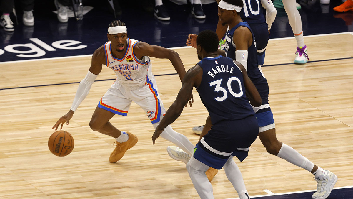 Oklahoma City Thunder guard Shai Gilgeous-Alexander (2) dribbles the ball against Minnesota Timberwolves forward Julius Randle (30) in the first half during game four of the western conference finals for the 2025 NBA Playoffs at Target Center.