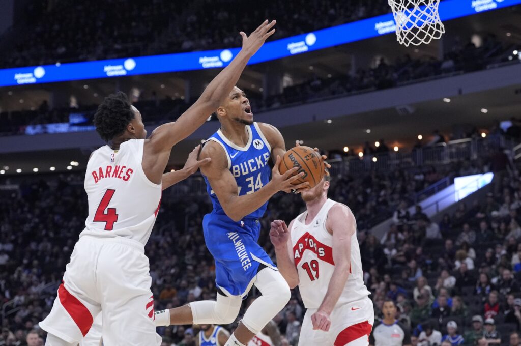 Jan 17, 2025; Milwaukee, Wisconsin, USA; Milwaukee Bucks forward Giannis Antetokounmpo (34) drives to the basket against Toronto Raptors forward Scottie Barnes (4) in the second half at Fiserv Forum. Mandatory Credit: Michael McLoone-Imagn Images