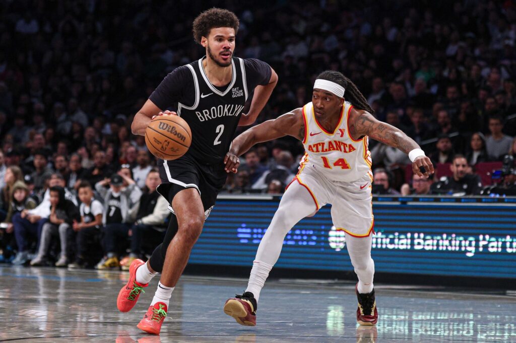 Mar 16, 2025; Brooklyn, New York, USA; Brooklyn Nets forward Cameron Johnson (2) dribbles against Atlanta Hawks guard Terance Mann (14) during the second half at Barclays Center. Mandatory Credit: Vincent Carchietta-Imagn Images