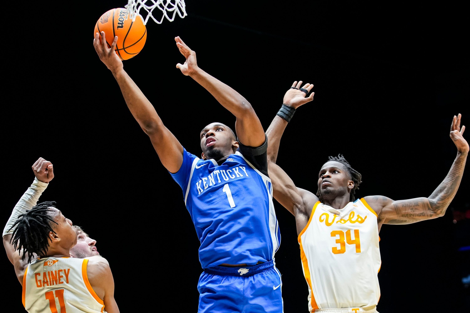 Kentucky Wildcats guard Lamont Butler (1) goes up for a basket against Tennessee Volunteers guard Jordan Gainey (11) and Tennessee Volunteers forward Felix Okpara (34) on Friday, March 28, 2025, during the NCAA Tournament Sweet 16 game at Lucas Oil Stadium in Indianapolis.