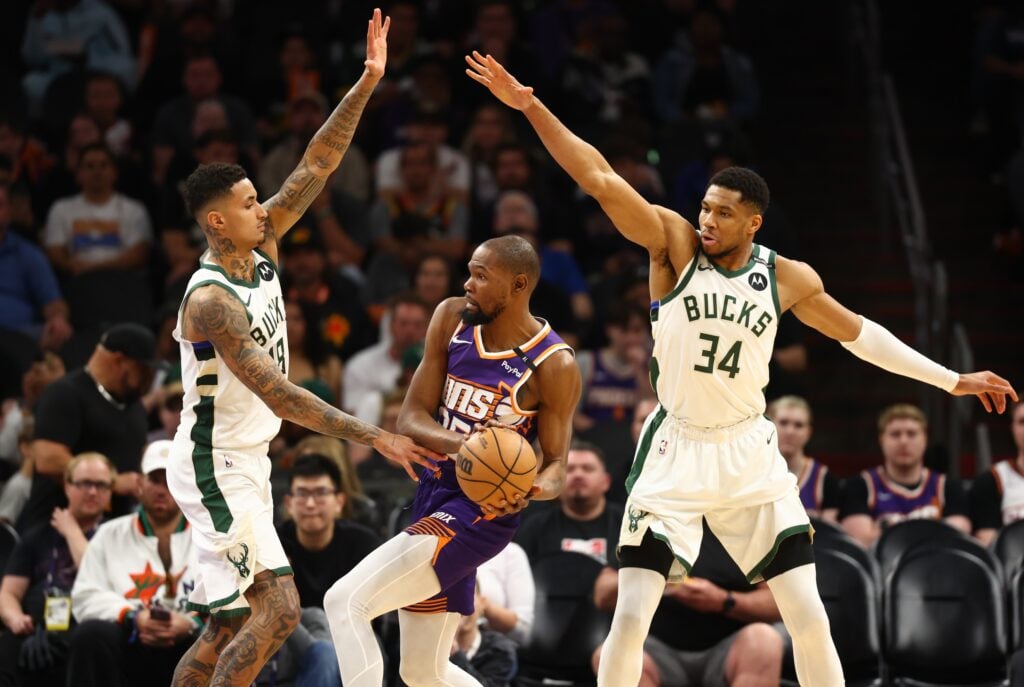 Mar 24, 2025; Phoenix, Arizona, USA; Milwaukee Bucks forward Kyle Kuzma (18) and forward Giannis Antetokounmpo (34) defend against Phoenix Suns forward Kevin Durant (35) at Footprint Center. Mandatory Credit: Mark J. Rebilas-Imagn Images