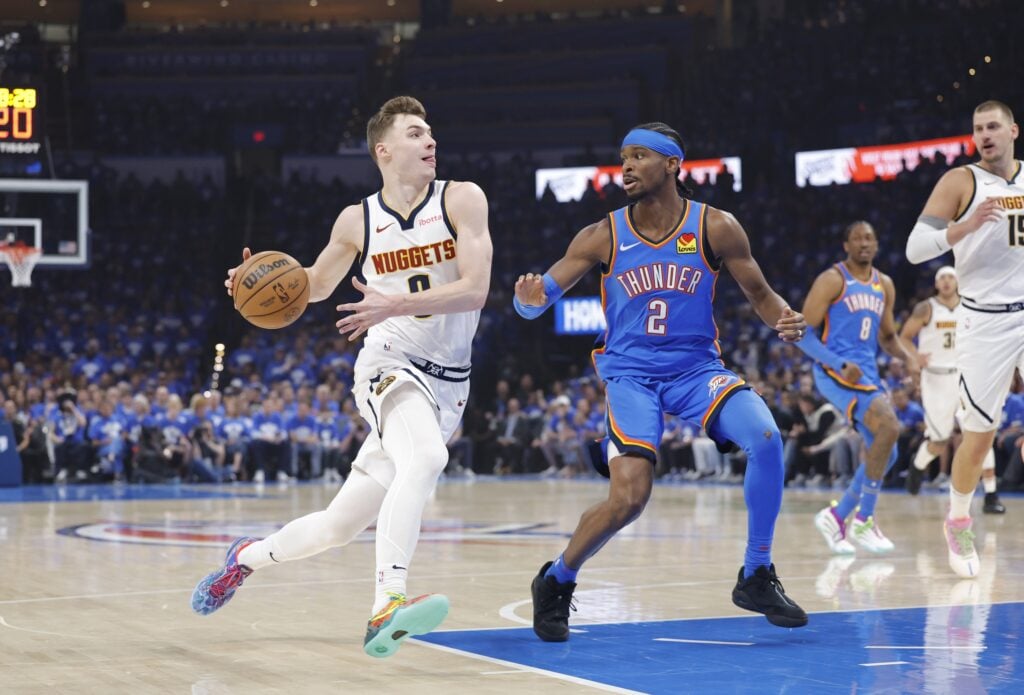 May 18, 2025; Oklahoma City, Oklahoma, USA; Denver Nuggets guard Christian Braun (0) drives to the basket beside Oklahoma City Thunder guard Shai Gilgeous-Alexander (2) in the first quarter during game seven of the second round for the 2025 NBA Playoffs at Paycom Center. Mandatory Credit: Alonzo Adams-Imagn Images