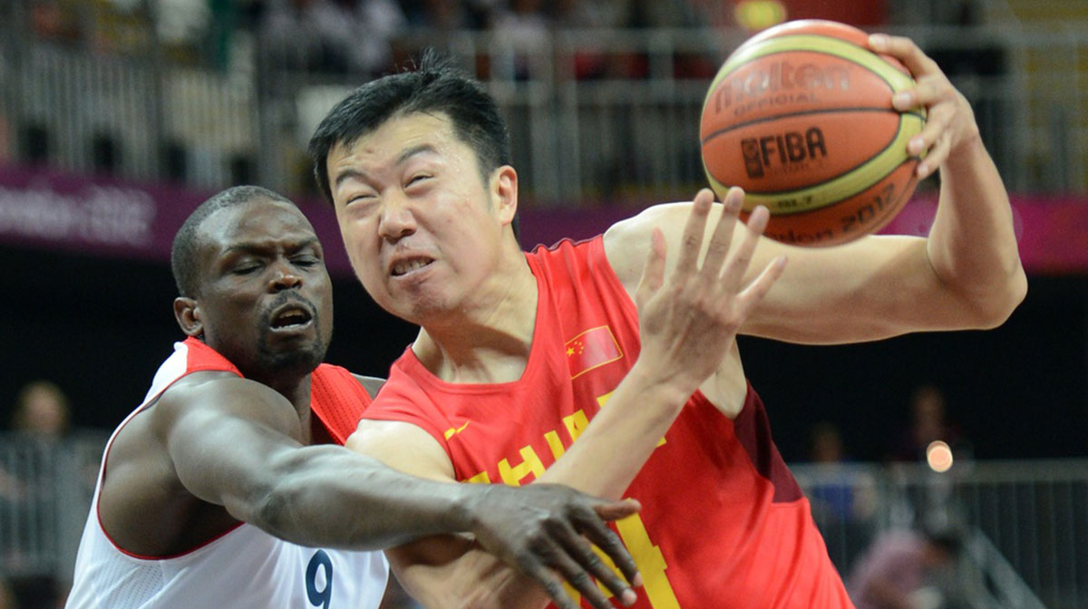 China center Wang Zhizhi (14) drives past Great Britain forward Luol Deng (9) during the men's basketball preliminary round game in the 2012 London Olympic Games at Basketball Arena.