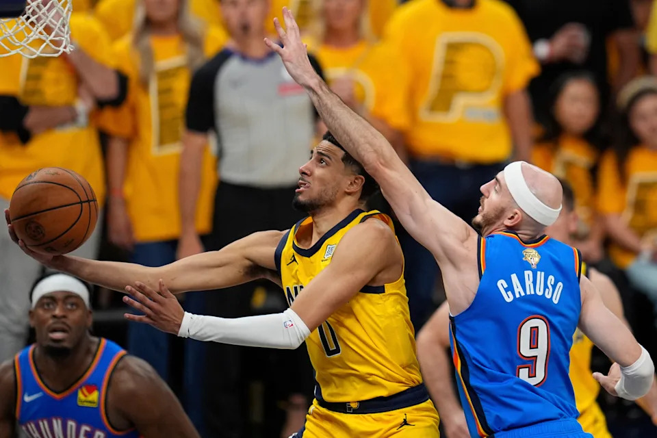 Indiana Pacers guard Tyrese Haliburton (0) shoots under Oklahoma City Thunder guard Alex Caruso (9) during the second half of Game 4 of the NBA Finals basketball series, Friday, June 13, 2025, in Indianapolis. (AP Photo/Abbie Parr)
