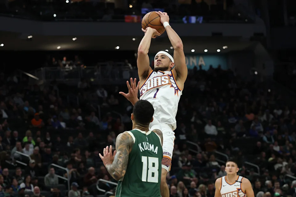 Devin Booker #1 of the Phoenix Suns shoots over Kyle Kuzma #18 of the Milwaukee Bucks during the first half of a game at Fiserv Forum on April 1, 2025, in Milwaukee.