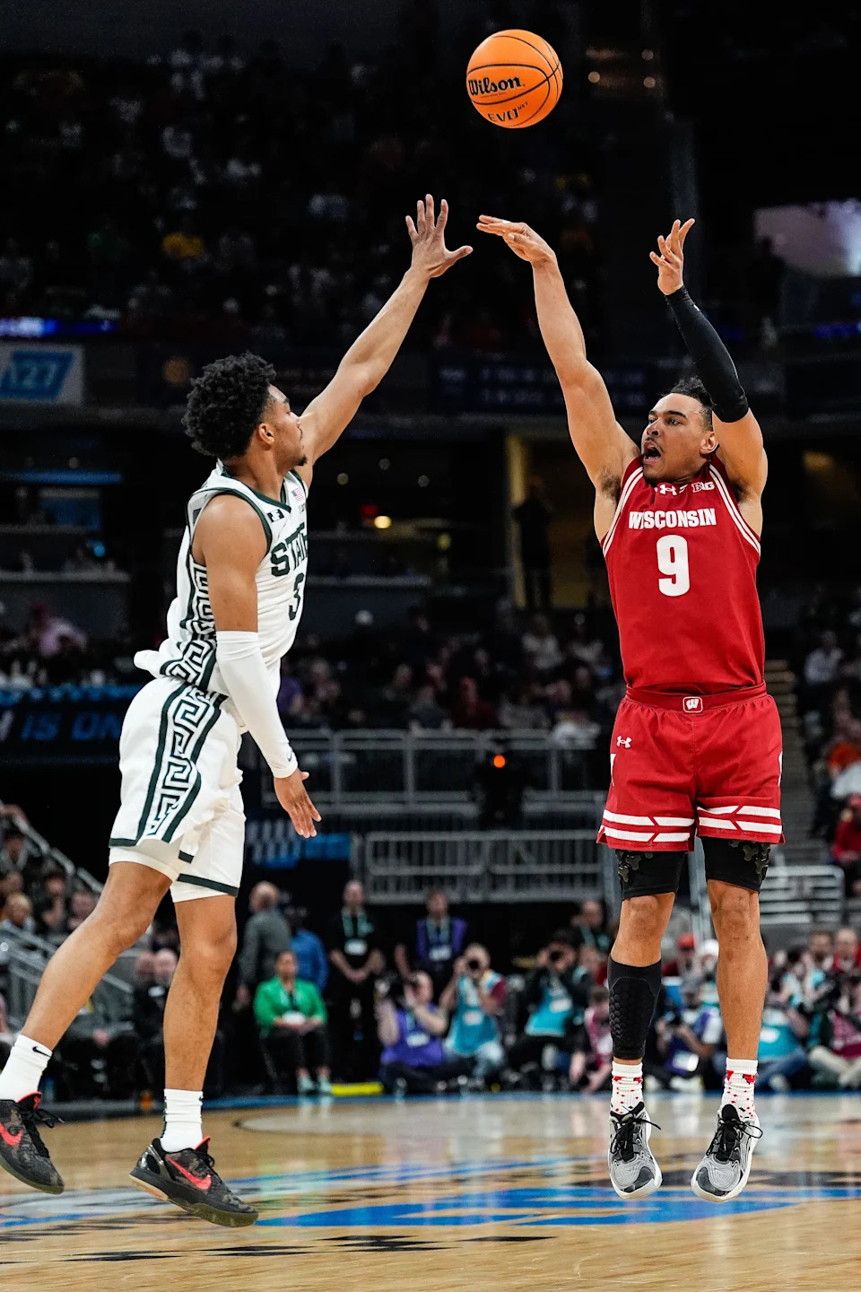 Wisconsin guard John Tonje (9) shoots a three point basket against Michigan State guard Jaden Akins (3) during the first half of Big Ten Tournament semifinal at Gainbridge Fieldhouse in Indianapolis, Ind. on Saturday, March 15, 2025.