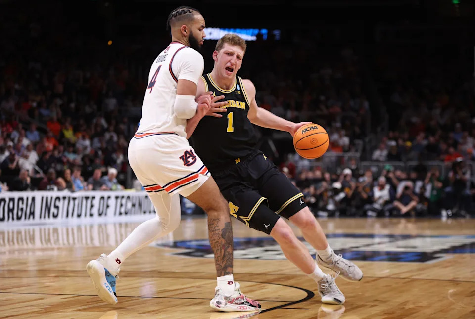 Michigan Wolverines center Danny Wolf (1) drives against Auburn Tigers forward Johni Broome (4) in the second half of a South Regional semifinal of the 2025 NCAA tournament at State Farm Arena in Atlanta on March 28, 2025.