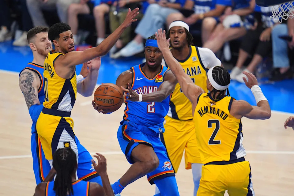 Oklahoma City Thunder guard Shai Gilgeous-Alexander (2) controls the ball against Indiana Pacers guard Tyrese Haliburton (0) and guard Andrew Nembhard (2) during the first half of Game 2 of the NBA Finals basketball series Sunday, June 8, 2025, in Oklahoma City. (AP Photo/Julio Cortez)