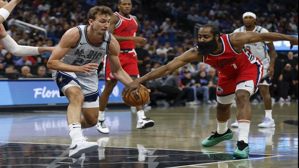 Los Angeles Clippers guard James Harden, right, strips Orlando Magic forward Franz Wagner, left, of ball during the first half of an NBA basketball game, Monday, March 31, 2025, in Orlando, Fla. (AP Photo/Kevin Kolczynski)