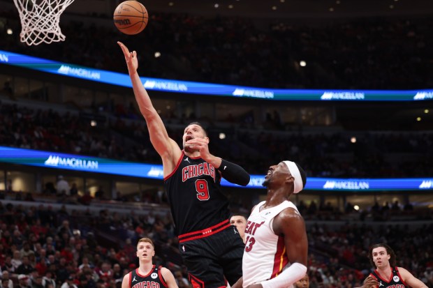 Chicago Bulls center Nikola Vucevic (9) goes up for a basket against Miami Heat center Bam Adebayo (13) during the first quarter of the first game of the play-in tournament at the United Center Wednesday April 16, 2025, in Chicago. (Armando L. Sanchez/Chicago Tribune)