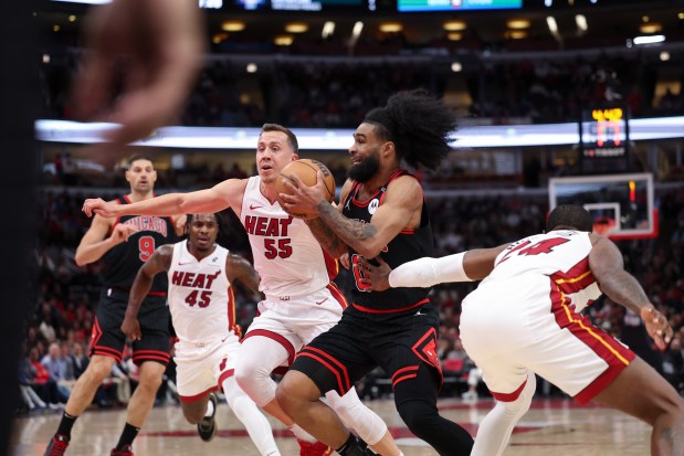 Miami Heat forward Duncan Robinson (55) and Miami Heat forward Haywood Highsmith (24) guard Chicago Bulls guard Coby White (0) during the second quarter of the first game of the play-in tournament at the United Center Wednesday April 16, 2025, in Chicago. (Armando L. Sanchez/Chicago Tribune)
