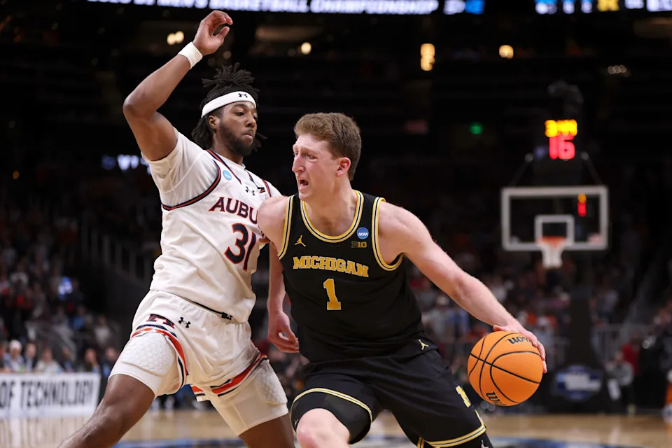 Mar 28, 2025; Atlanta, GA, USA; Michigan Wolverines center Danny Wolf (1) drives against Auburn Tigers forward Chaney Johnson (31) in the second half of a South Regional semifinal of the 2025 NCAA tournament at State Farm Arena. Mandatory Credit: Brett Davis-Imagn Images