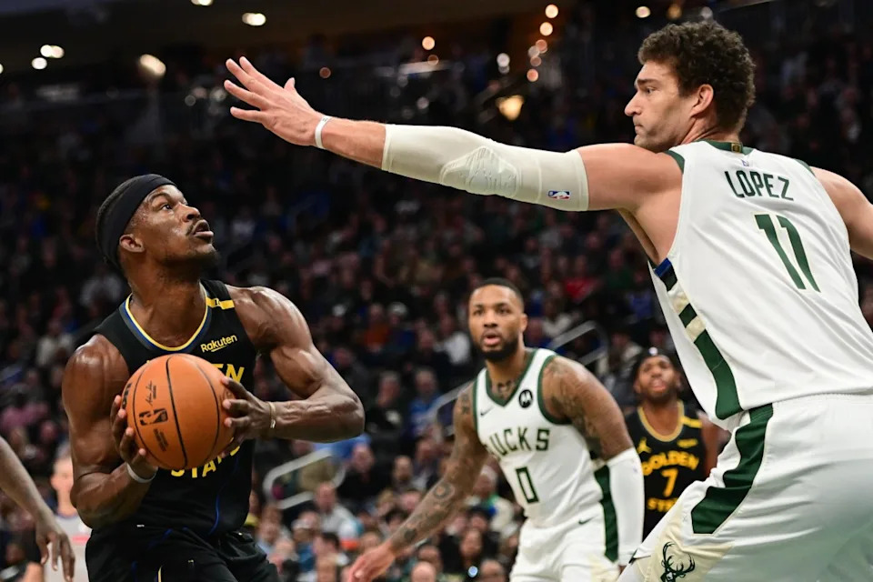 Golden State Warriors forward Jimmy Butler (10) looks for a shot against Milwaukee Bucks center Brook Lopez (11) in the first quarter at Fiserv Forum.Mandatory Credit: Benny Sieu-Imagn Images