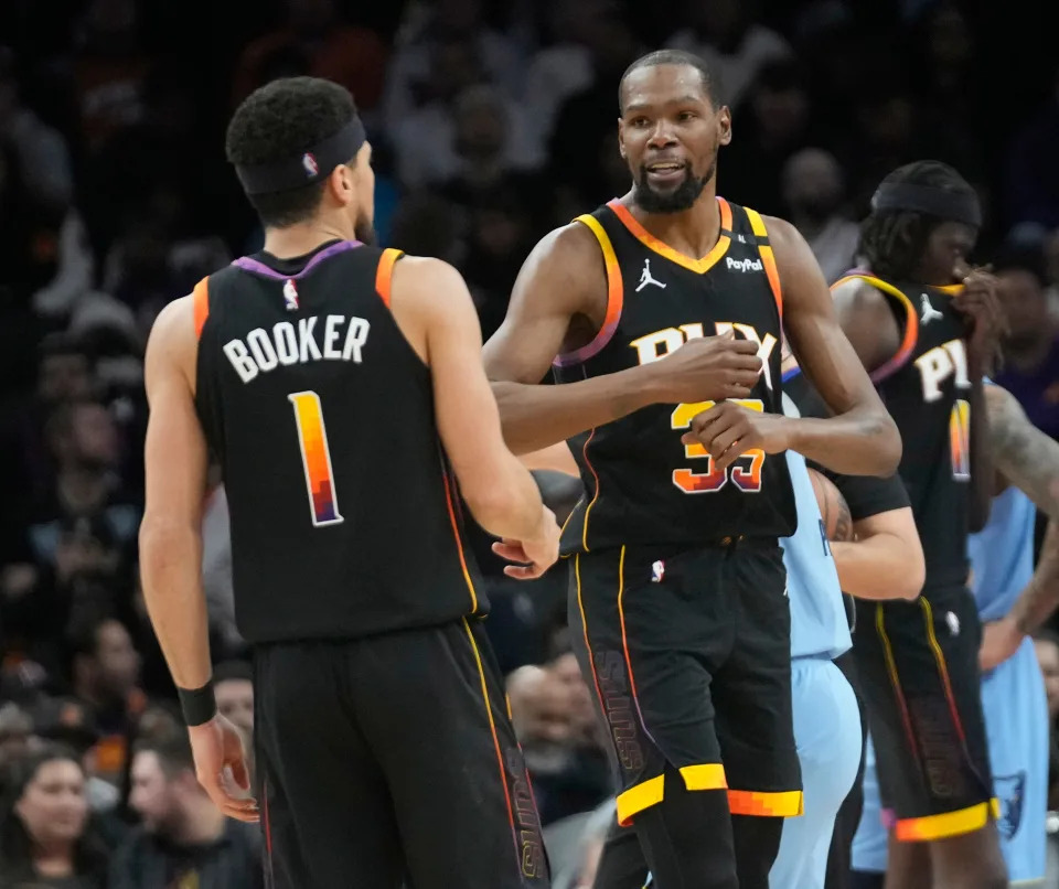 Phoenix Suns guard Devin Booker (1) and forward Kevin Durant (35) talk during the second quarter against the Memphis Grizzlies at Footprint Center in Phoenix on Feb. 11, 2025.