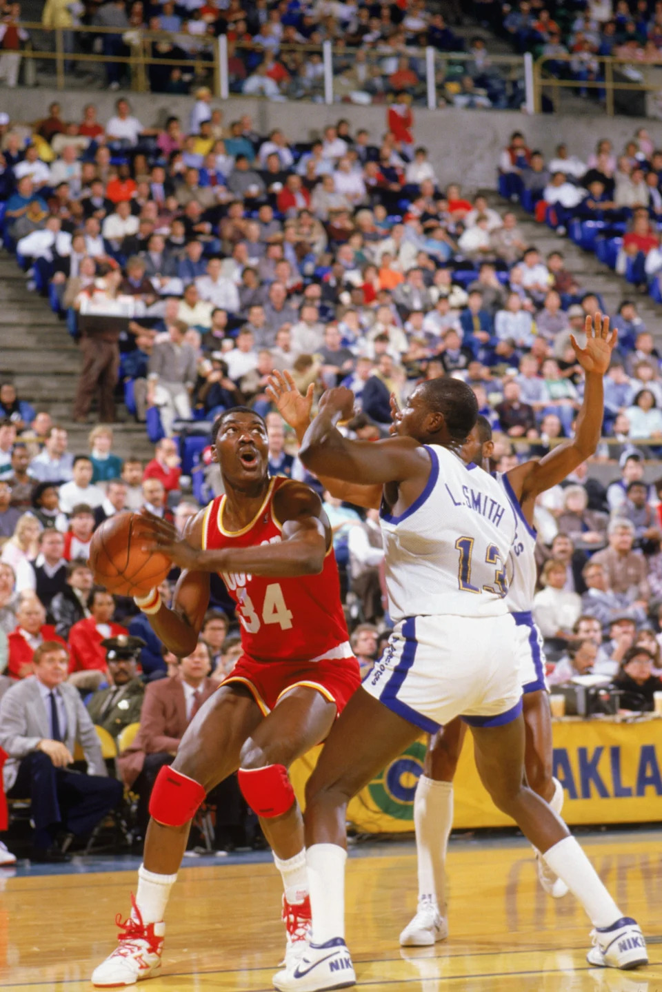 1987: Akeem Olajuwon #34 of the Houston Rocket takes a shot against Larry Smith #13 of the Golden State Warriors during a game in the 1987-88 season. NOTE TO USER: User expressly acknowledges and agrees that, by downloading and/or using this Photograph, User is consenting to the terms and conditions of the Getty Images License Agreement. (Photo by: Otto Greule Jr/Getty Images)