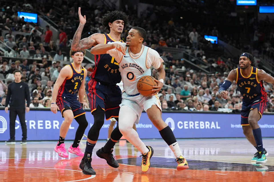 Mar 30, 2025; San Antonio, Texas, USA; San Antonio Spurs forward Keldon Johnson (0) drives in against Golden State Warriors forward Gui Santos (15) in the second half at Frost Bank Center.© Daniel Dunn-Imagn Images