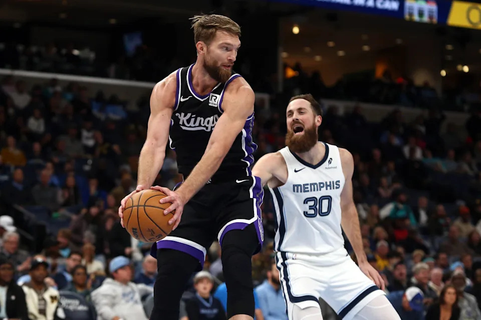 Dec 5, 2024; Memphis, Tennessee, USA; Sacramento Kings forward Domantas Sabonis (11) collects a rebound over Memphis Grizzlies center Jay Huff (30) during the second quarter at FedExForum.Mandatory Credit&colon; Petre Thomas-Imagn Images