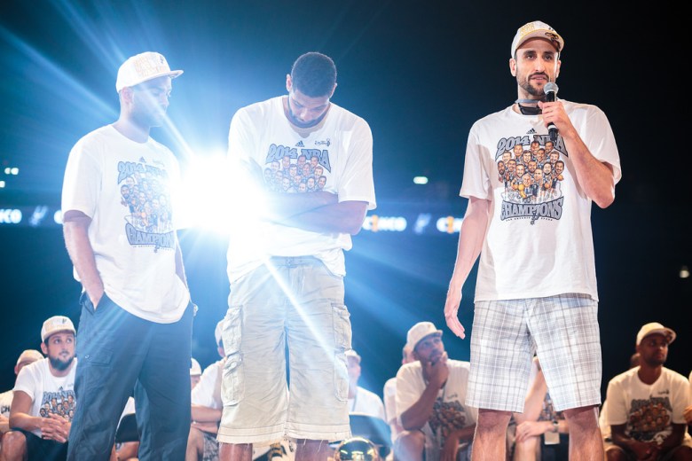 Spurs Manu Ginóbili speaks to the crowd while Tony Parker and Tim Duncan look on during the Spurs celebration at the Alamodome of their 2014 NBA Finals victory. Photo by Scott Ball.