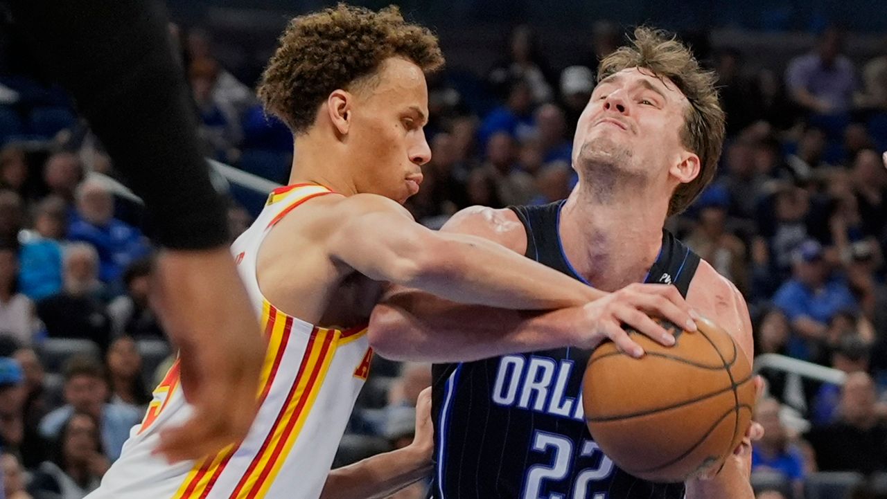 Atlanta Hawks guard Dyson Daniels, left, fouls Orlando Magic forward Franz Wagner (22) as he attempts a shot during the second half of an NBA basketball game, Tuesday, April 8, 2025, in Orlando, Fla. (AP Photo/John Raoux)