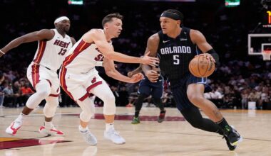 Magic forward Paolo Banchero (5) drives to the basket against Heat forward Duncan Robinson (55) and center Bam Adebayo (13) during the first half of Orlando's victory in their first game of the 2024-25 NBA season on Wednesday, Oct. 23, 2024, in Miami. (AP Photo/Wilfredo Lee)