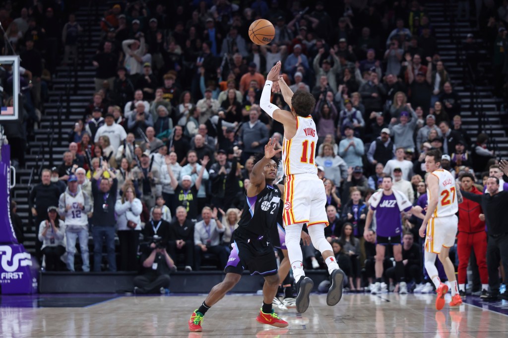 Atlanta Hawks guard Trae Young (11) shoots a three point shot from half court over Utah Jazz guard Collin Sexton (2) at the buzzer to win an NBA basketball game, Tuesday, Jan. 7, 2025, in Salt Lake City. 