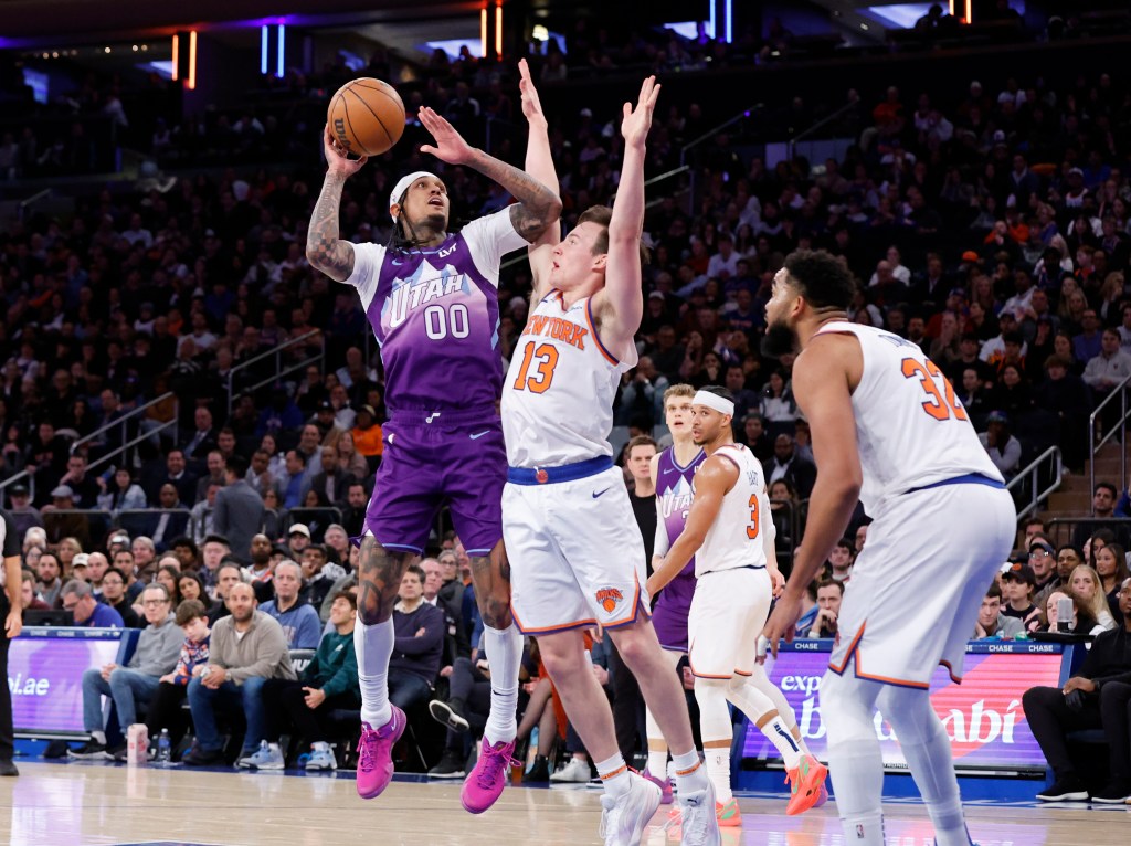 Utah Jazz player Jordan Clarkson shoots over a New York Knicks player.