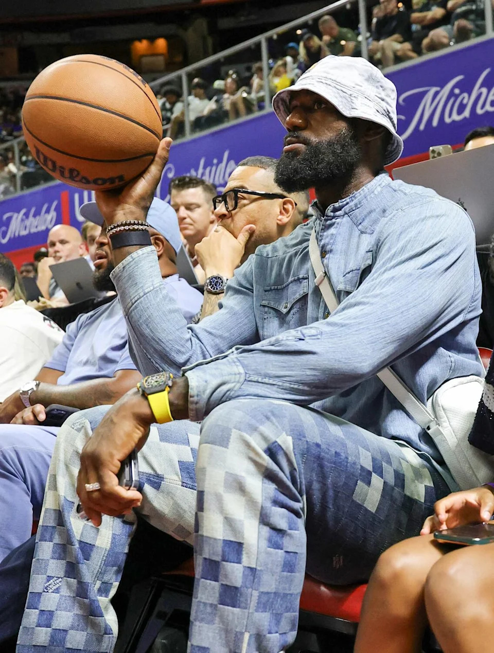 Lakers star LeBron James sits courtside during the team's NBA Summer League game in Las Vegas on Saturday.