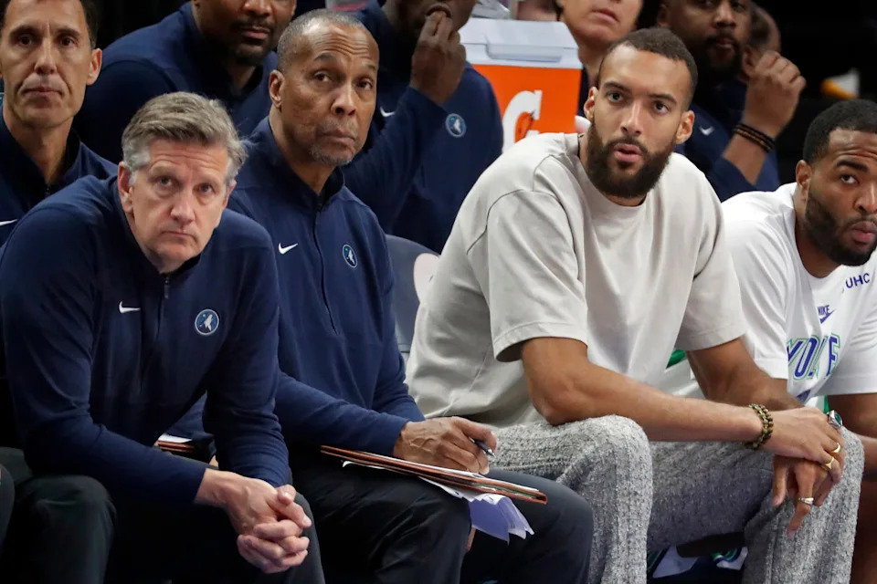 Mar 19, 2024; Minneapolis, Minnesota, USA; Minnesota Timberwolves head coach Chris Finch and assistant coach Elston Turner and center Rudy Gobert (27) sit as they watch the team play the Denver Nuggets in the third quarter at Target Center. Mandatory Credit: Bruce Kluckhohn-USA TODAY Sports