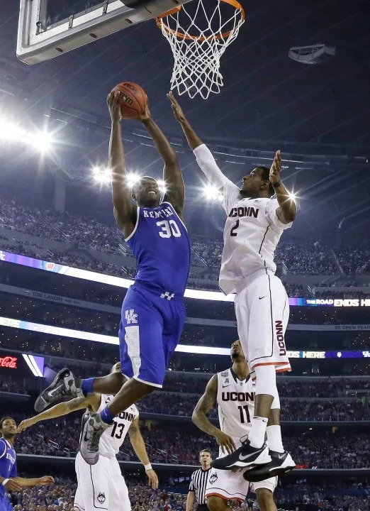 Kentucky forward Julius Randle, left, drives to the basket past Connecticut forward DeAndre Daniels (2) during the second half of the NCAA Final Four tournament college basketball championship game Monday, April 7, 2014, in Arlington, Texas. (AP Photo/David J. Phillip)