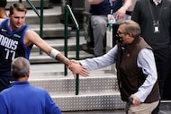 Dallas Mavericks guard Luka Doncic (77) reaches back for General Manager Donnie Nelson as...