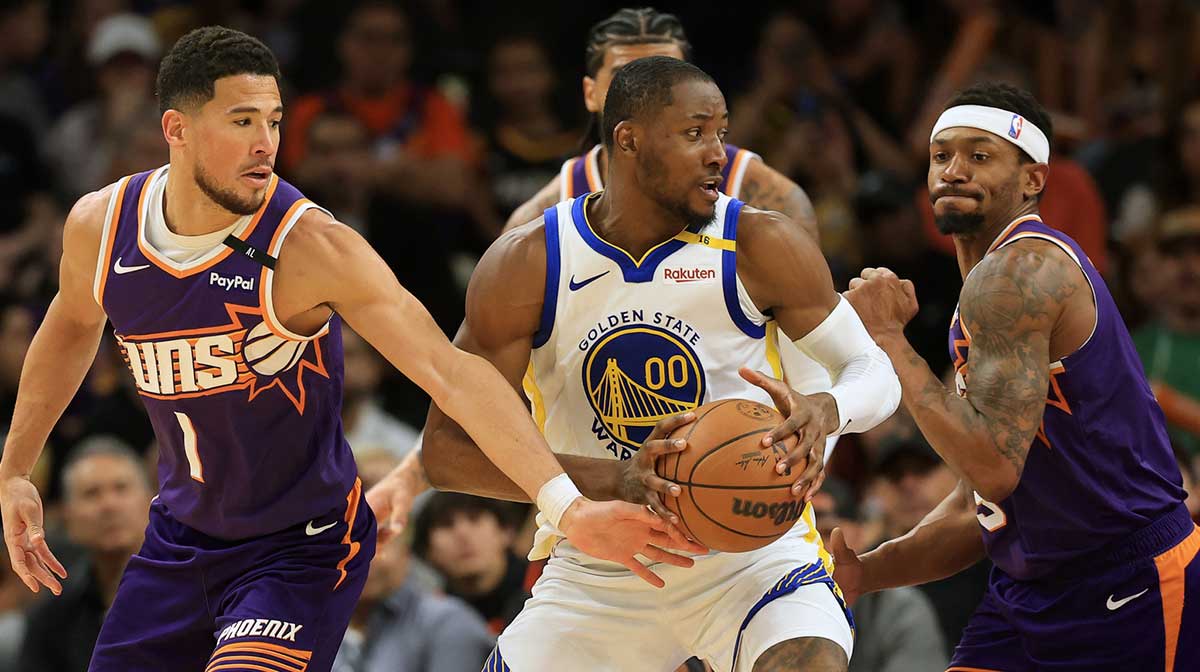 Golden State Warriors forward Jonathan Kuminga (00) dribbles the ball against Phoenix Suns guard Devin Booker (1) during the second half at Footprint Center.