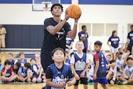 Dallas Mavericks guard Max Christie shoots hoops as he makes an appearance at Mavs Academy...
