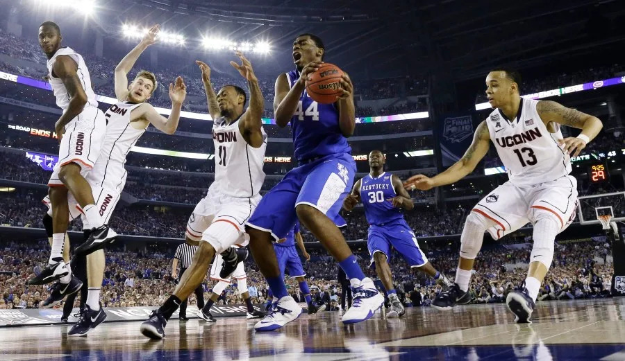 Kentucky center Dakari Johnson (44) grabs the ball between defenders Connecticut guard Ryan Boatright (11) and guard Shabazz Napier (13) during the second half of the NCAA Final Four tournament college basketball championship game Monday, April 7, 2014, in Arlington, Texas. (AP Photo/David J. Phillip)