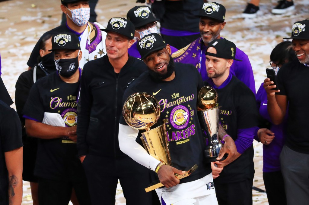 LeBron James holding the NBA championship trophy with the Lakers team.
