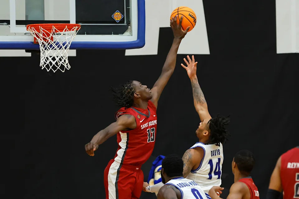 Rasheer Fleming #13 of the Saint Joseph's Hawks blocks a shot by Dre Davis #14 of the Seton Hall Pirates during the second half of a first-round NIT game at Walsh Gym on March 20, 2024, in South Orange, New Jersey. Seton Hall defeated Saint Joseph's 75-72 in overtime.