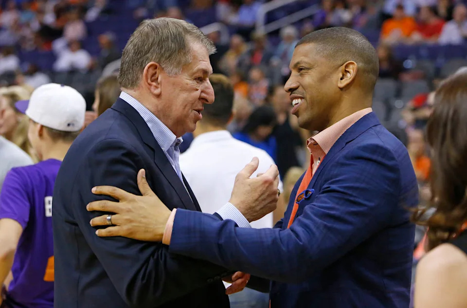 Jerry Colangelo greets Former Phoenix Suns Kevin Johnson during half time of their NBA game Sunday, Feb. 23, 2014 in Phoenix. Johnson was honored during the ceremony.